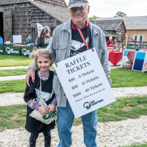 Volunteer Paul Hecht with his helper Isabella sell raffle tickets at the event. Photo by Lisa Tamburini.