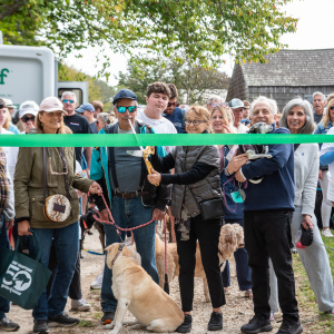 Laura Pintchik, the 2024 Top Fundraiser cuts the ribbon to start the 2025 Dog Walk! Photo by Lisa Tamburini.